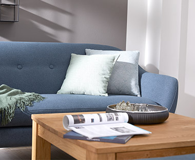 Sofa in Blau mit Holzfarbenden Couchtisch