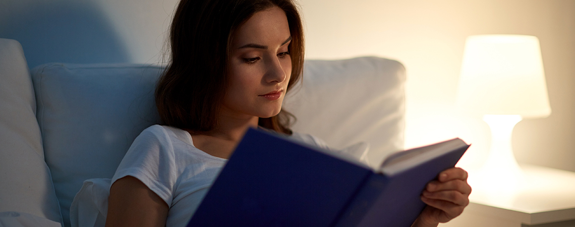 Frau liest ein Buch im Bett