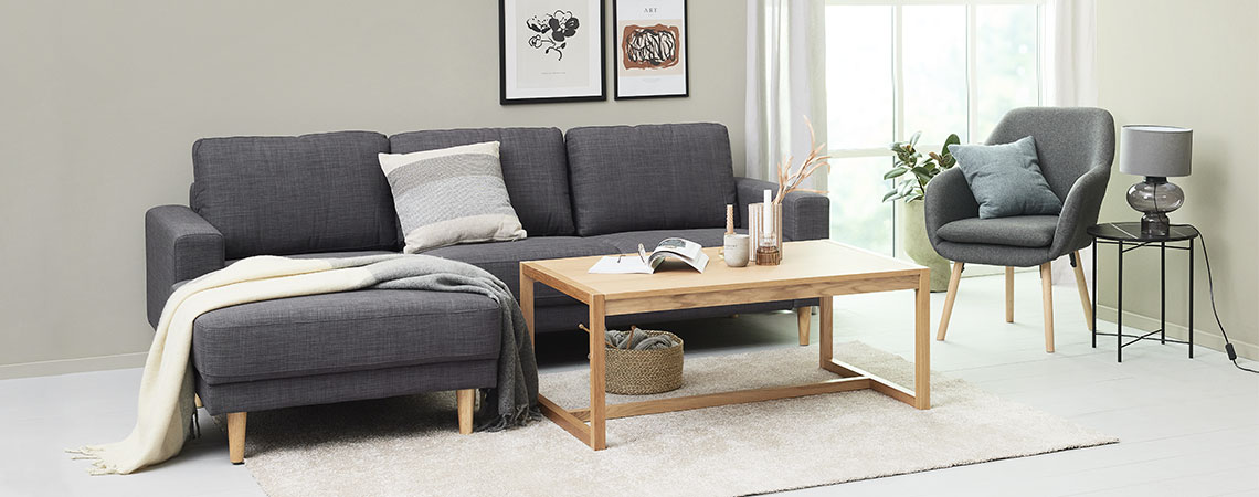 Wohnzimmer mit Sofa, Couchtisch, Sessel und Hochflor-Teppich