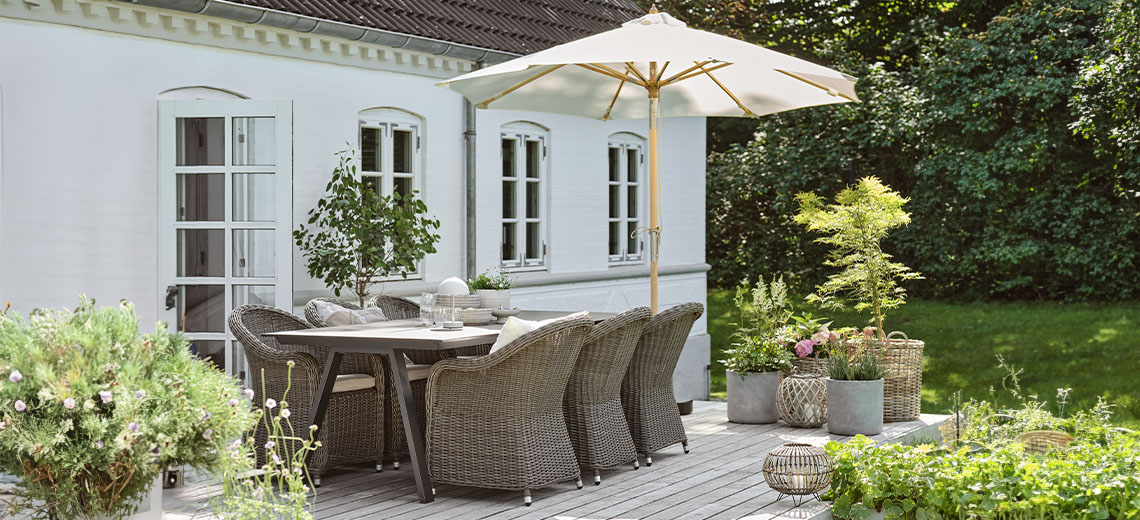 Sonnenschirm auf Terrasse mit Gartentisch und -stühlen