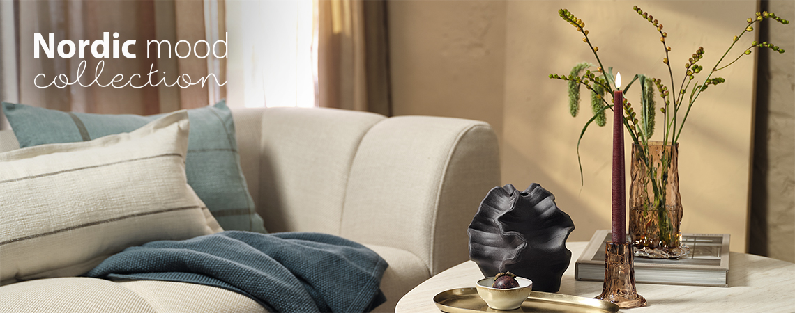 Wohnzimmer mit Sofa, Couchtisch, OTTO Glasvase, Kerzenhalter, GUDMUND LED-Kerze und Dekokissen KLOKKELYNG und HALLON