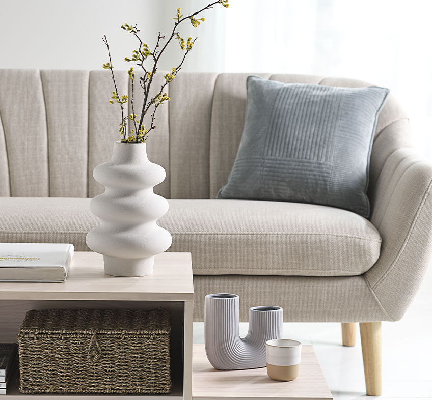 Helles Wohnzimmer mit Verspielten Vasen auf Kaffeetisch und beiges Sofa 