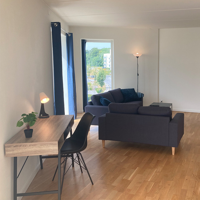 Esszimmerstuhl KLARUP, Schreibtisch ABBETVED und Sofas EGENSE Möbliertes Wohnzimmer mit Schreibtisch, Stuhl und Couches