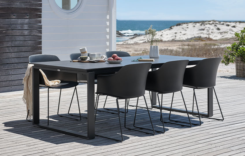 Großer Gartentisch und Stühle auf der Veranda am Strand