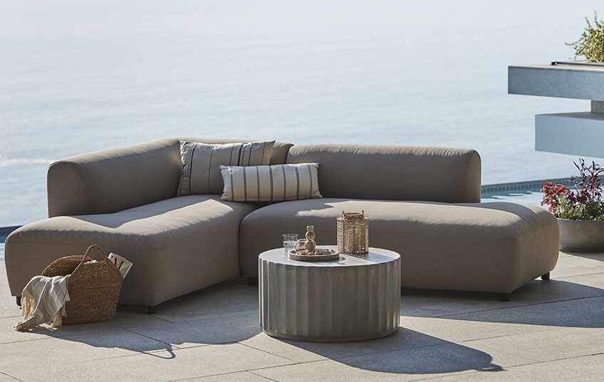 Allwetter-Loungesofa in Beige und Loungetisch auf einer Terrasse