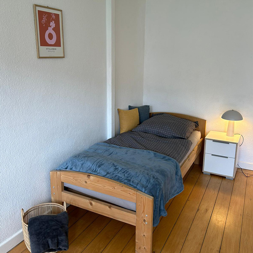 Möblierter Schlafbereich mit Decken, Lampe und Zubehör