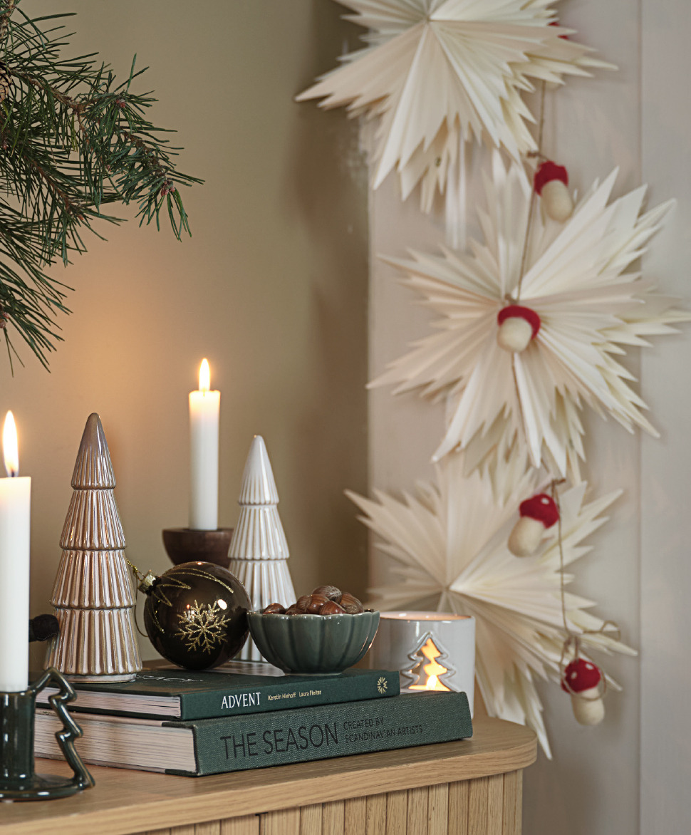 Short descriptionEin Sideboard mit schönem Weihnachtsschmuck und Papiersternen an der Wand