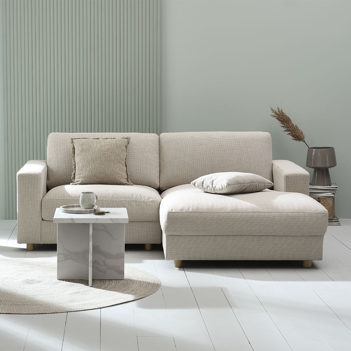 Beiges 2-Sitzer-Sofa mit Chaiselongue in einem modernen und minimalistischen Wohnbereich