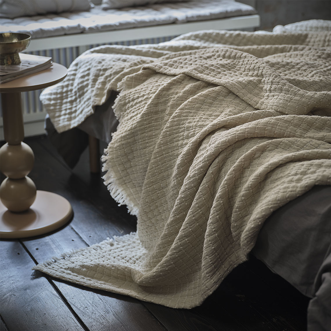 Beige Decke auf einem Bett in einem Schlafzimmer