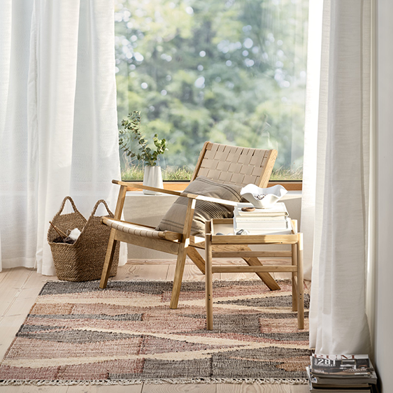 Skandinavisches Design Eine kleine Sitzecke mit einem Sessel an einem großen Fenster