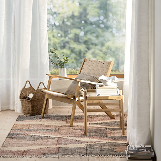 Eine kleine Sitzecke mit einem Sessel an einem großen Fenster