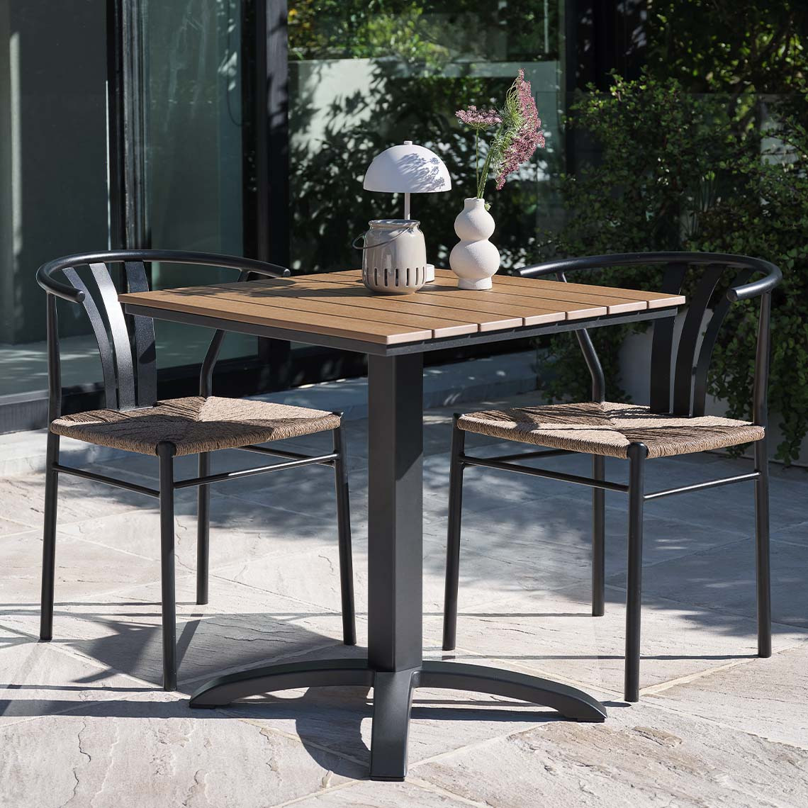 Wartungsfreier HOBRO-Bistrotisch und TAGMARK-Gartenstühle Wartungsfreier Gartentisch und Gartenstühle im modernen Stil auf der Terrasse