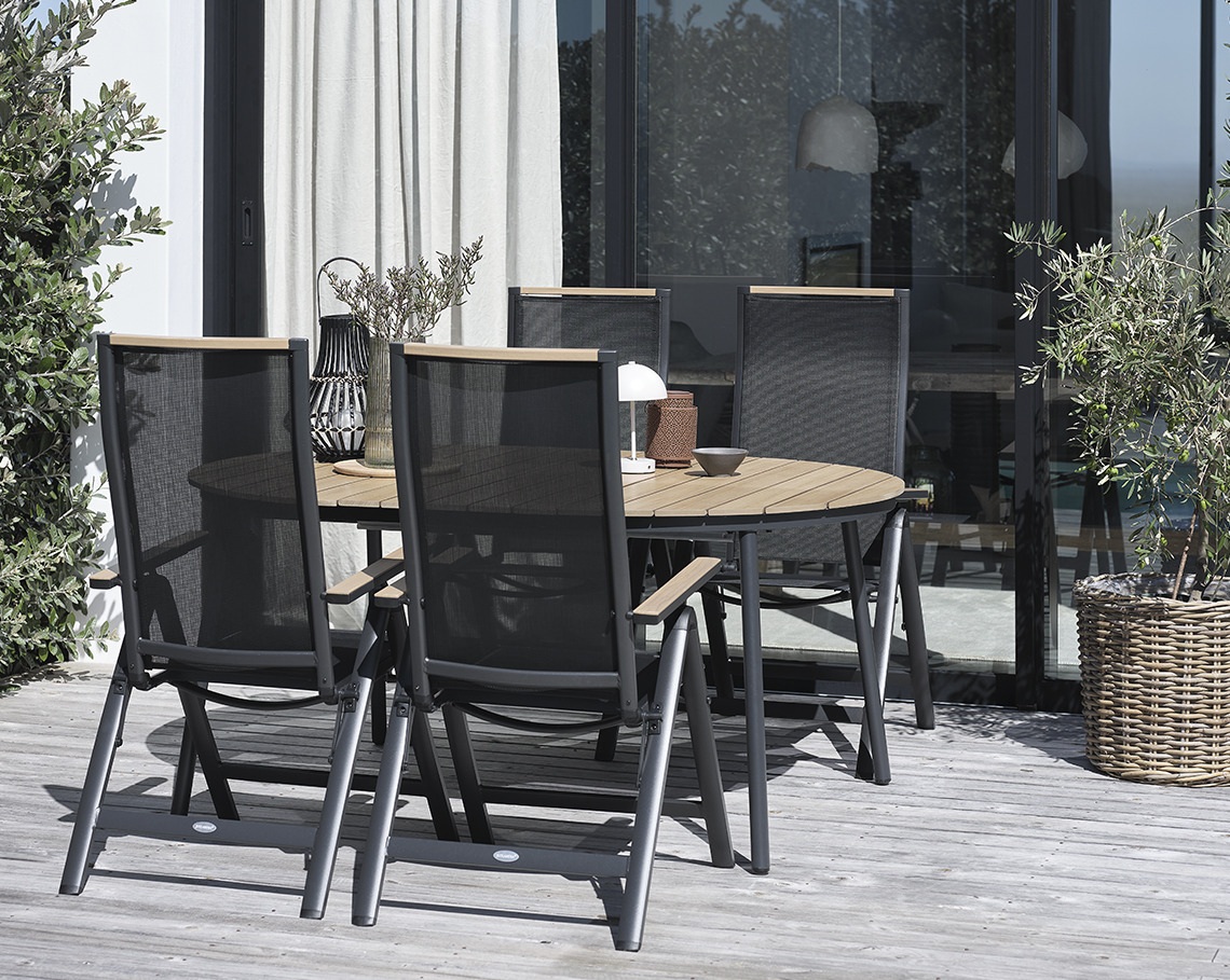 TAGEHOLM Gartentisch mit BREDSTEN Gartenstühlen Ovaler Gartentisch mit Gartenstühlen auf einer Veranda