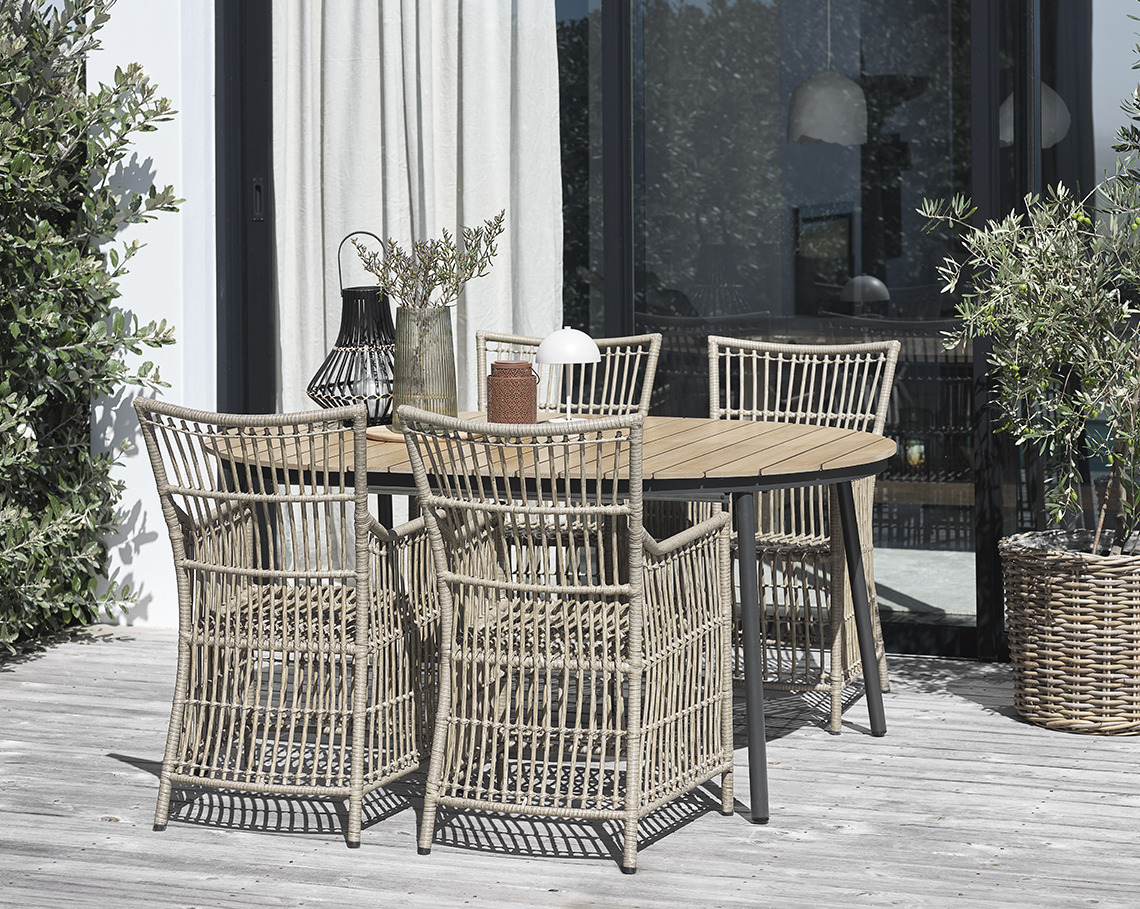 TAGEHOLM Gartentisch mit FJELLERUP Gartenstühlen Ovaler Gartentisch mit vier Gartenstühlen auf einer Veranda