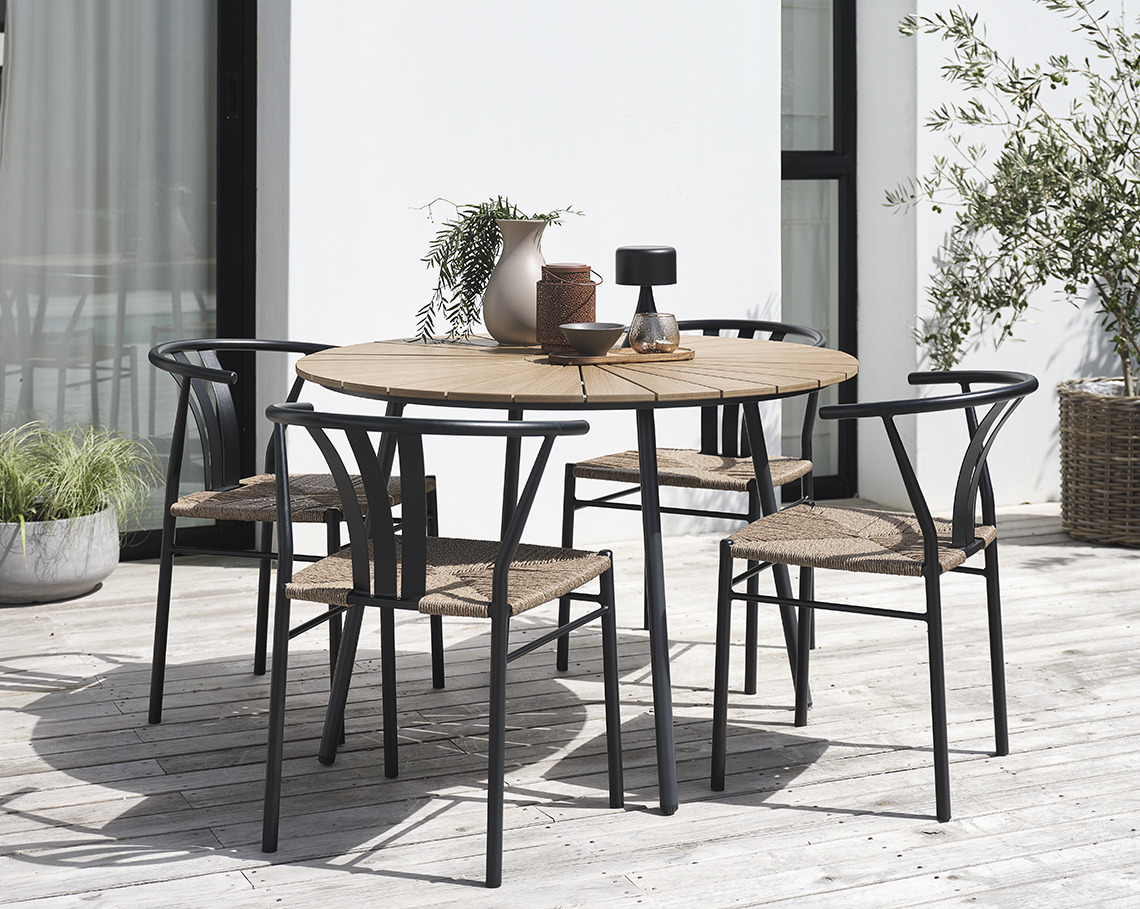 RANGSTRUP Gartentisch mit einem Durchmesser von 130 cm und TAGMARK Gartenstühle Runder Gartentisch mit vier Gartenstühlen auf einer Veranda