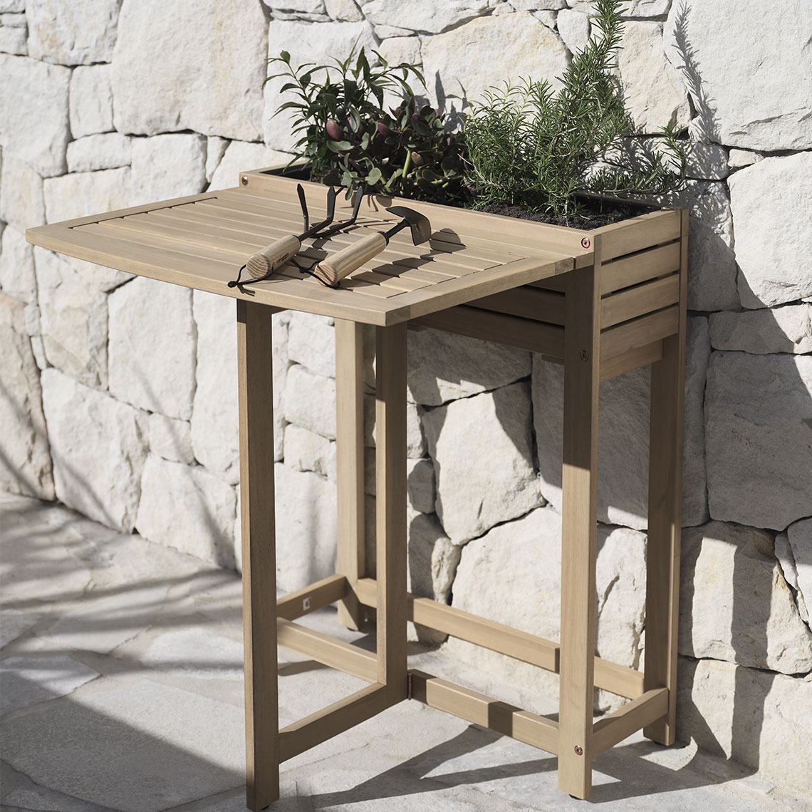 Klappbarer Tisch aus Hartholz mit eingebautem Pflanzkasten auf einer Terrasse