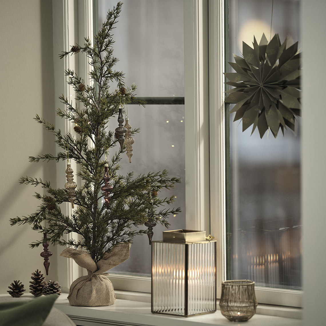 FENRIR Weihnachtsbaum mit LUCIA-Deko, UVIT Laterne, SAFRAN Teelichthalter und HRYM Weihnachtsstern Teelichthalter, Laterne und künstlicher Weihnachtsbaum mit Dekorationen auf der Fensterbank