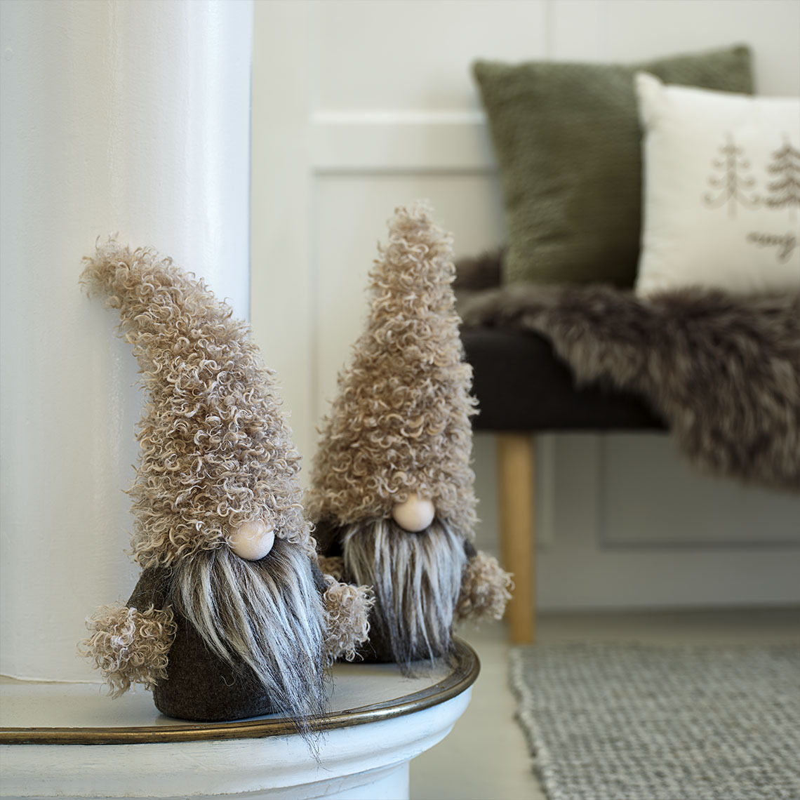 Kleine dekorative Weihnachtswichtel in den Farben grün und braun auf einem Sideboard. Kleine dekorative Weihnachtswichtel in den Farben grün und braun auf einem Kaminvorsprung.