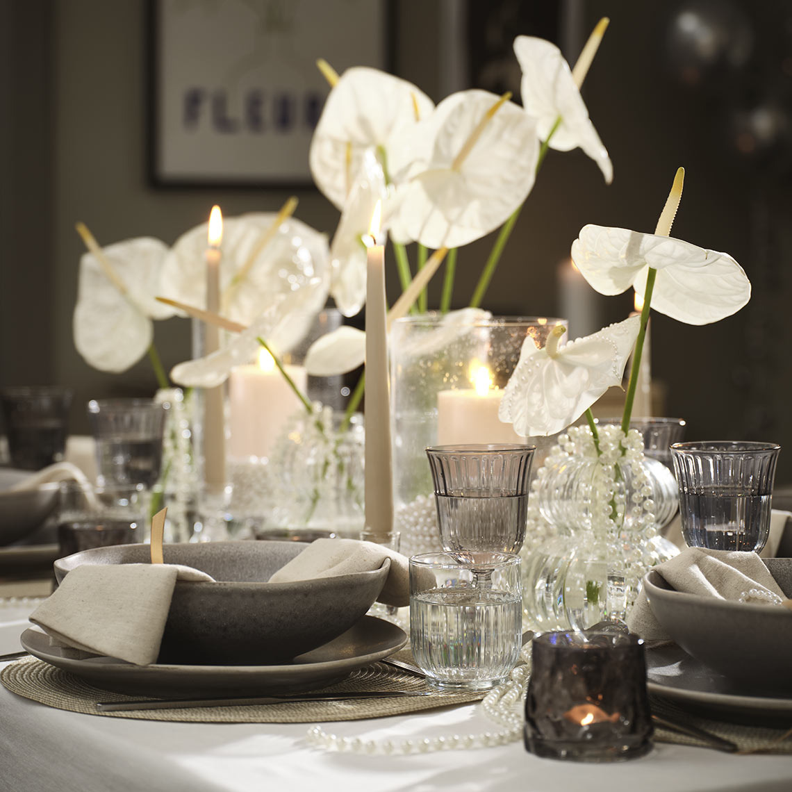 Tisch gedeckt mit Schalen, Tellern, Gläsern und Teelichthaltern