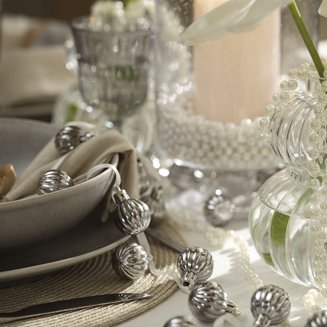 Weihnachtskugeln auf einer Schnur auf dem Esstisch