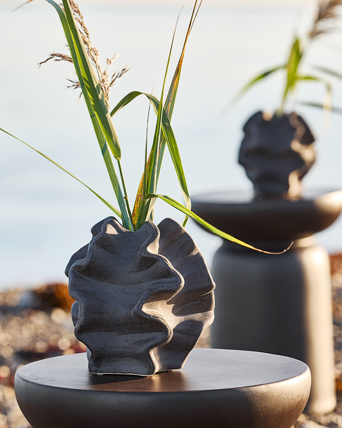 Vase VILHELM Vase mit organischer Form auf einem Podest am Strand