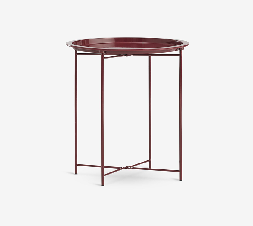 Colours Round burgundy metal tray-top side table with slender legs and a cross brace, shown against a plain white background.