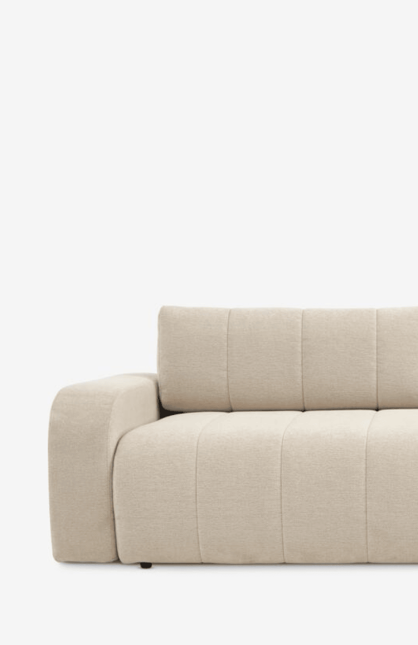 Sofa beds Close-up of a beige modular sofa with channel-tufted cushions and a low armrest, against a plain white background.