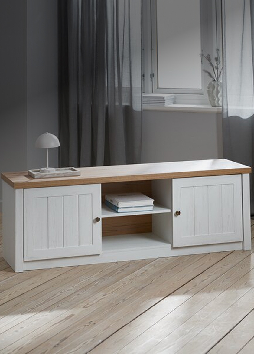 TV benches White and oak TV bench with two cabinet doors and an open center shelf, in front of a curtained window with a table lamp on top.