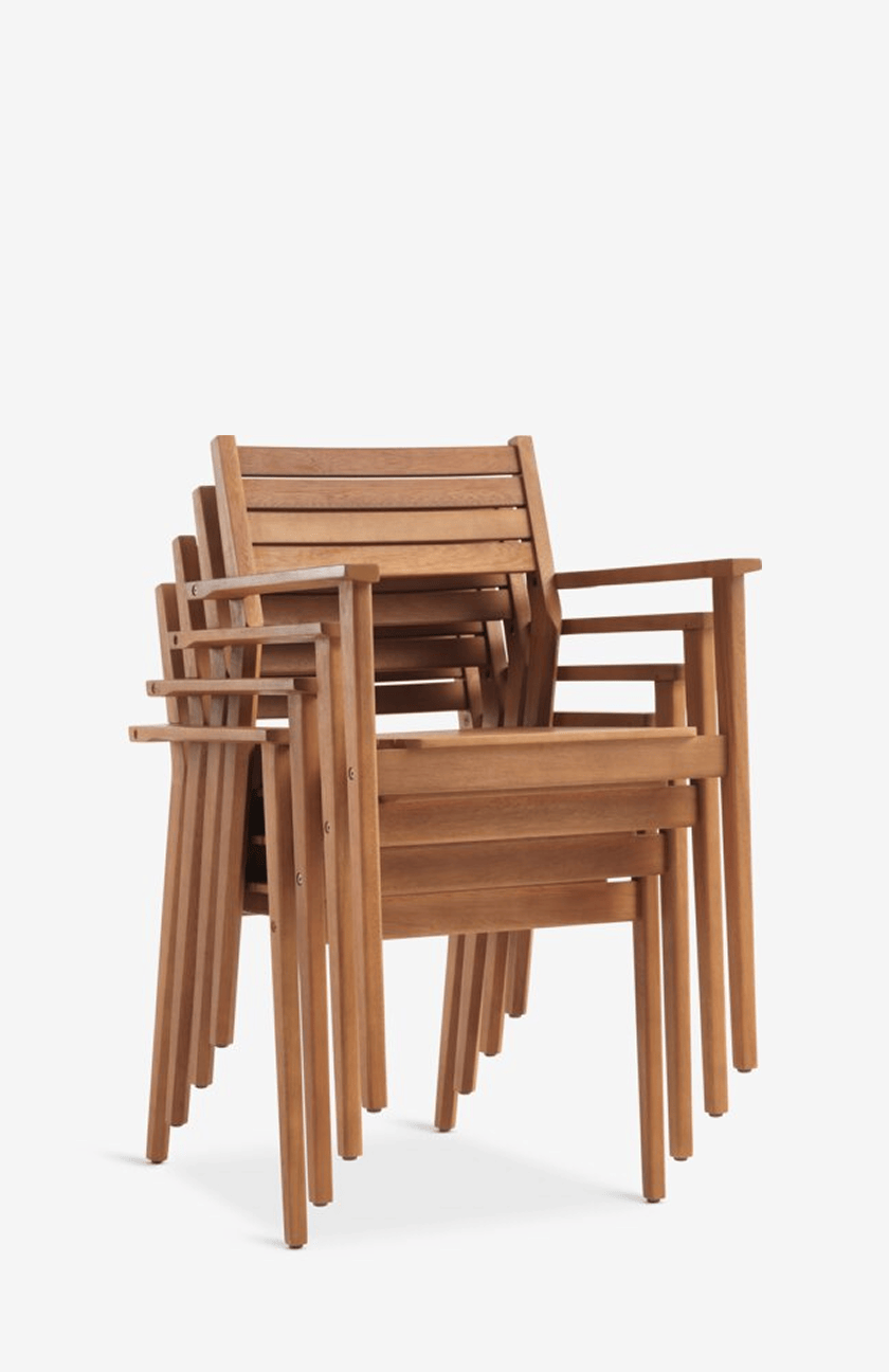 Wooden chairs Stack of four wooden outdoor armchairs with slatted backs and seats, shown against a plain white background.