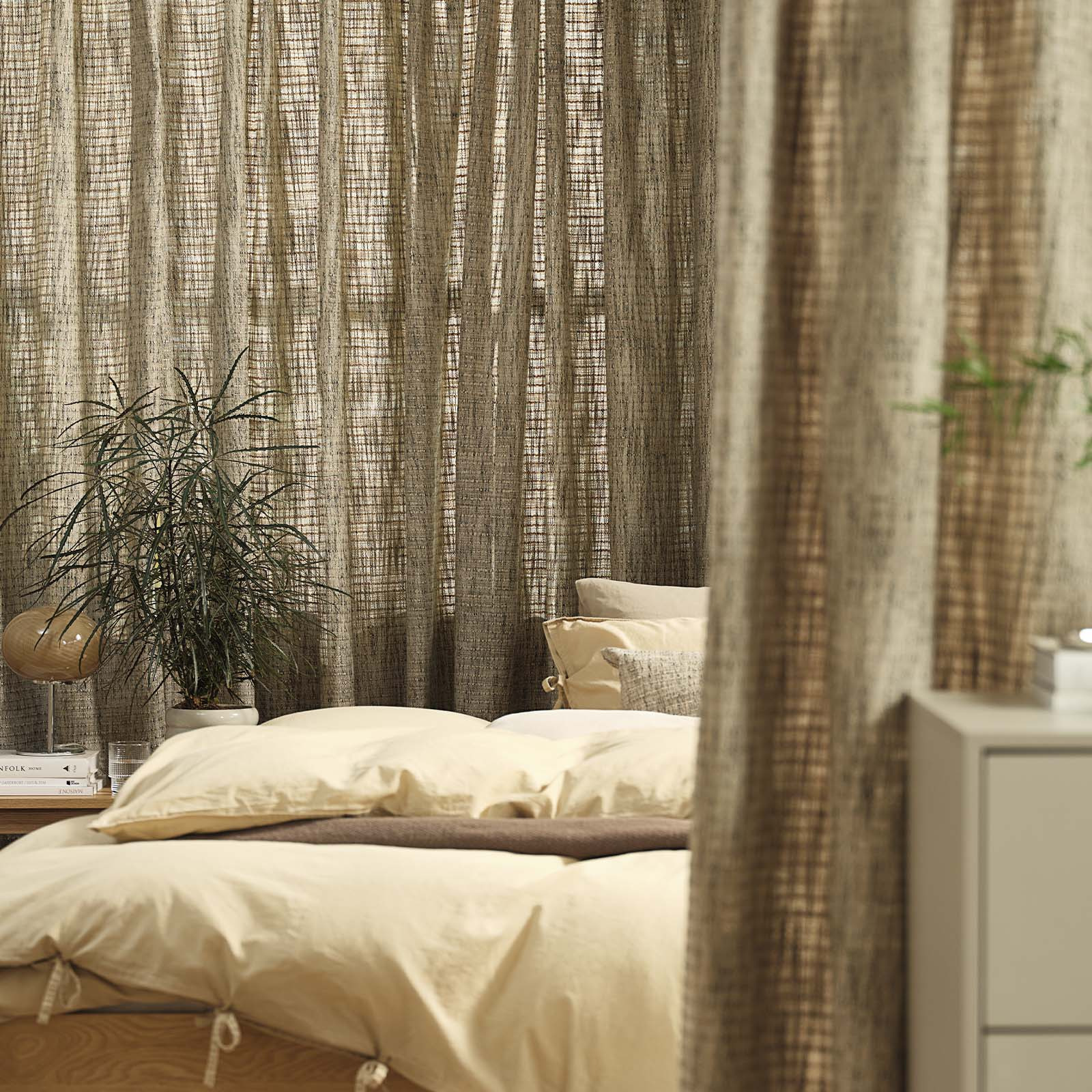 Fenster mit einem sandgrünen schweren Vorhang im Schlafzimmer