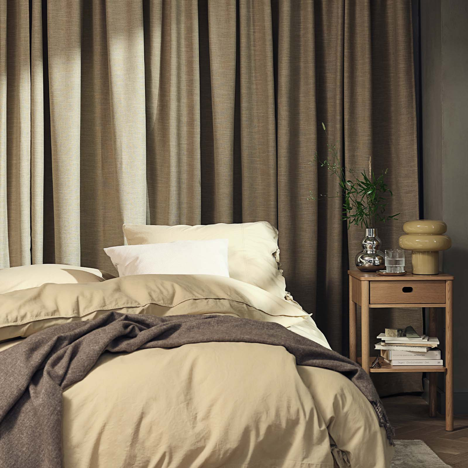 Schlafzimmer mit einem großen schweren Vorhang in Khaki