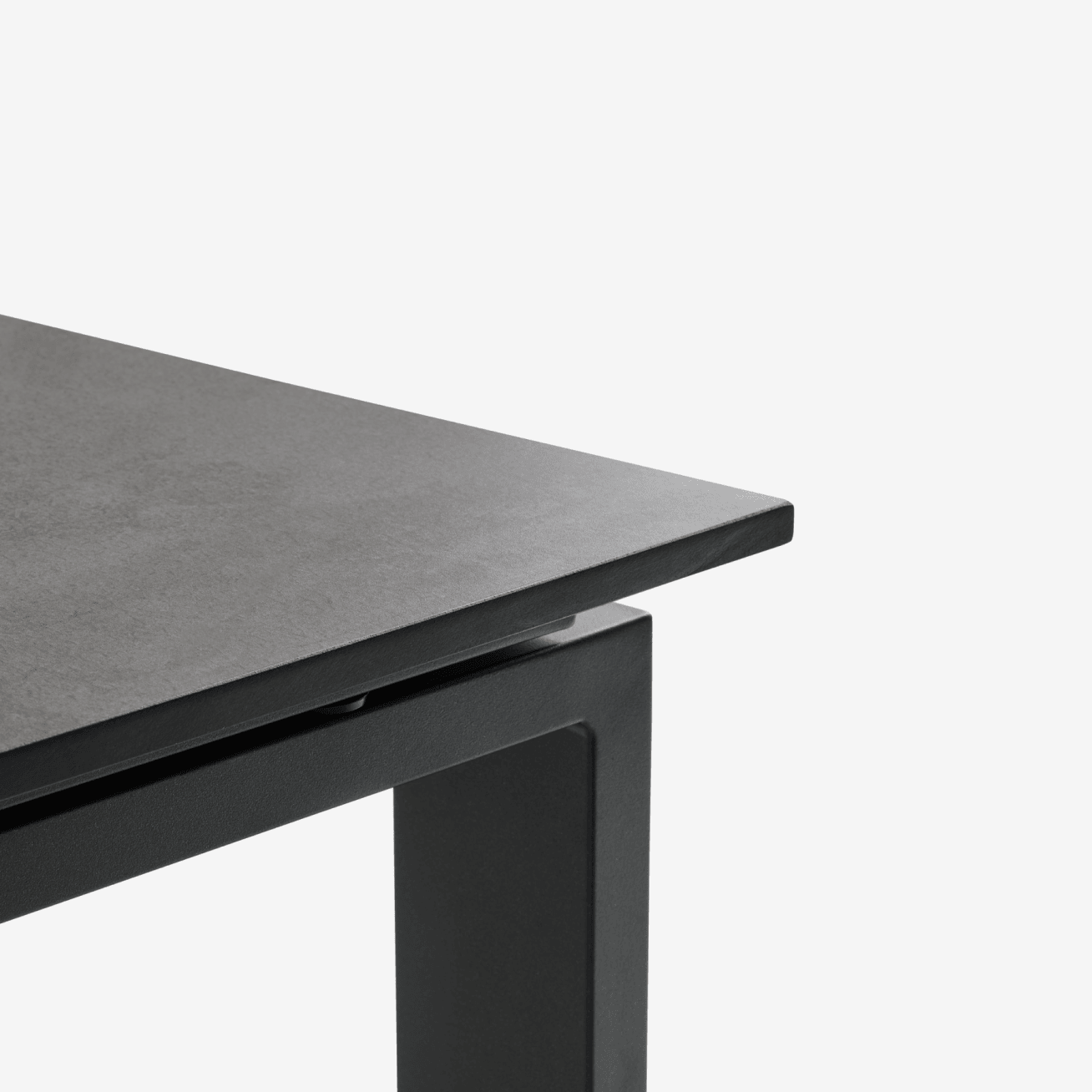 Composite tables - Square Close-up corner of a black composite-top table with a black metal frame, shown against a plain white background.