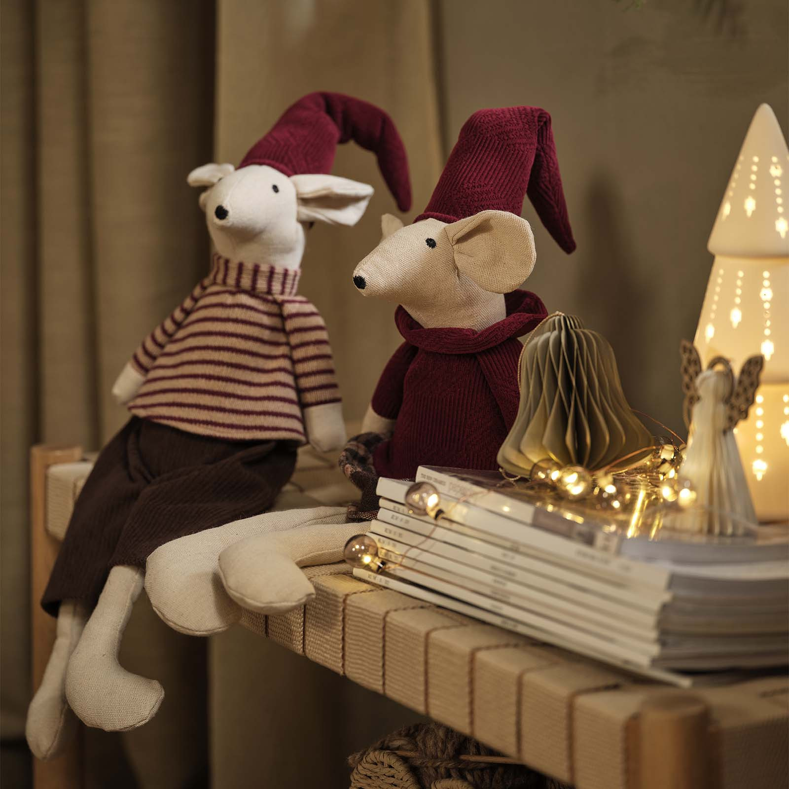 Die Weihnachtsmäuse JULKLAPP ekorative Weihnachtsmäuse mit spitzen, bordeauxroten Weihnachtsmützen auf einem Tagesbett