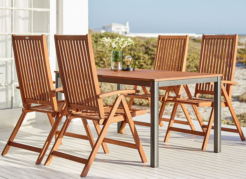 Gartenmöbel aus Holz auf einer Terrasse am Meer