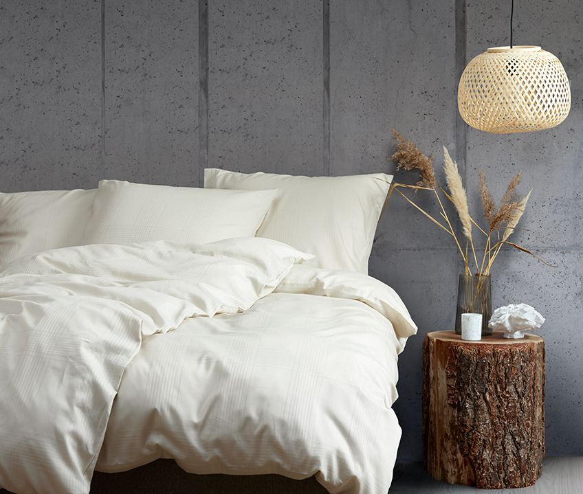 Elegantes Schlafzimmer im ruhigem nordischen Look und Bett aus sandfarbener Bettwäsche