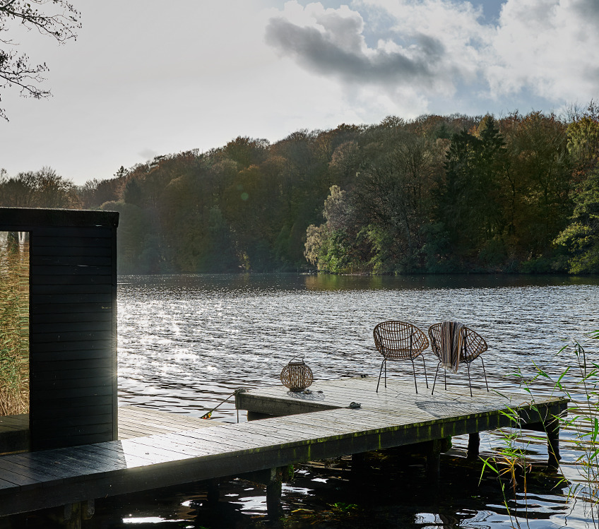 Badetuch hängt einen Loungesessel auf einem Steg am See