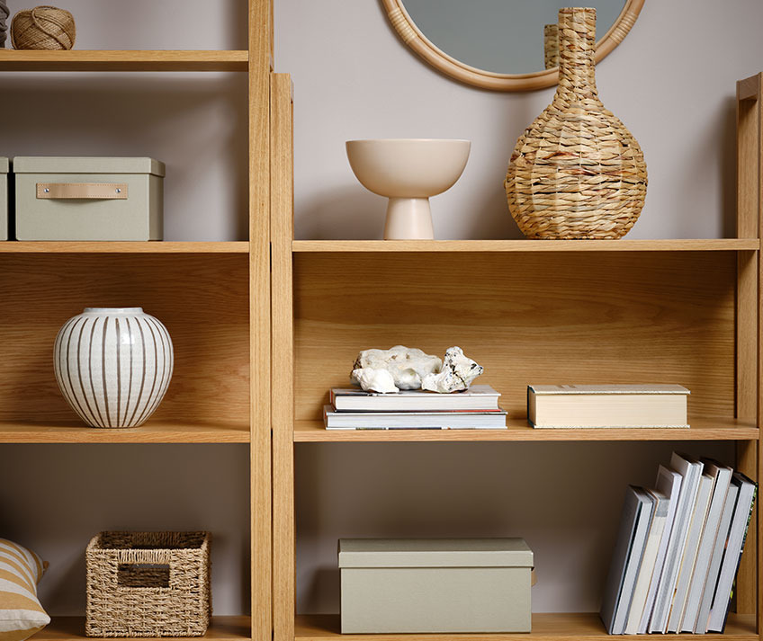 Bücherregal mit Korb aus Naturmaterialien, Schale, Aufbewahrungsboxen und anderen Dekorationsartikeln