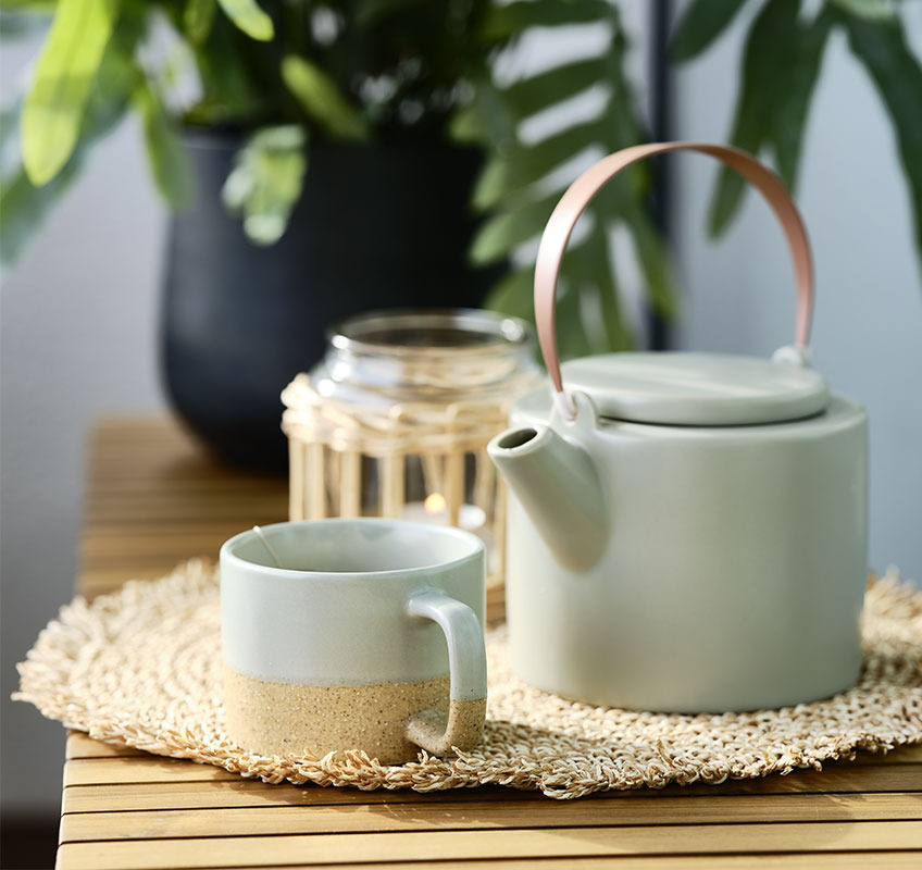 UGILT-Gartenbank, GAUTE-Teekanne und HALFDAN-Tasse GGartenbank mit Teekanne und Becher darauf