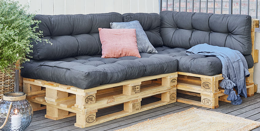 Paletten-Ecksofa mit Palettenkissen auf einer Terrasse