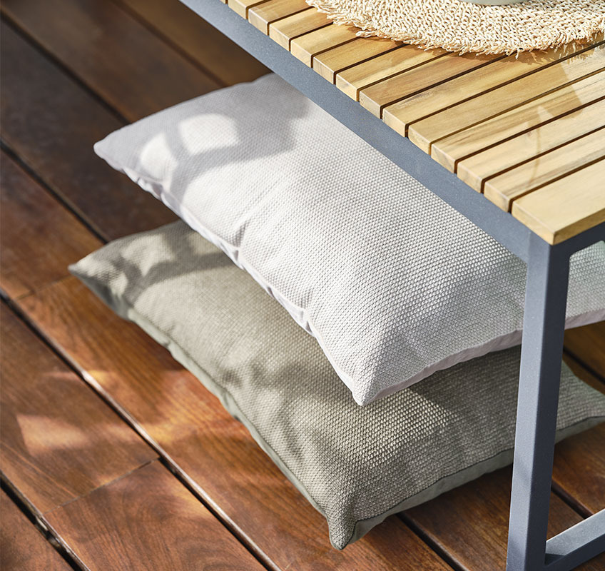 LILJE-Kissen in Grün und Beige Balkon mit Holzboden und zwei Kissen in Grün und Beige