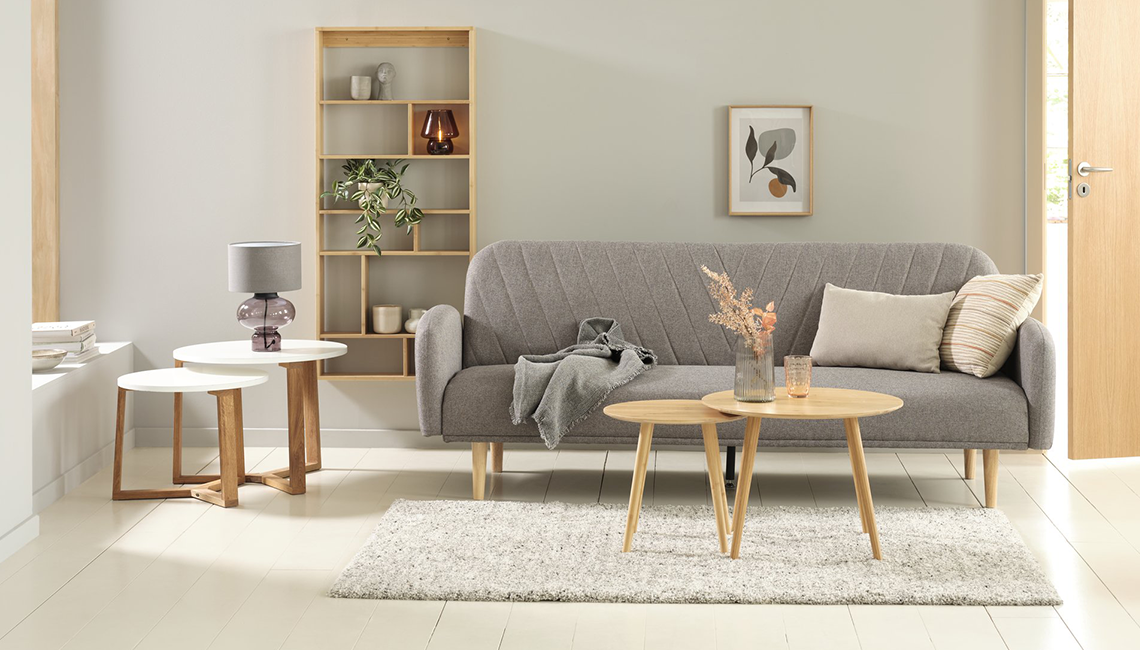 Schlafsofa PARADIS hellgrau Schlafsofa in hellgrau steht im Wohnzimmer