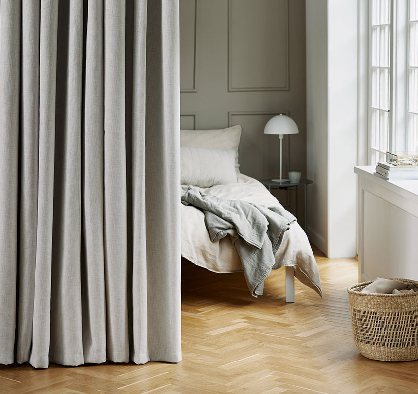 Verdunklungs-Vorhang als Raumteiler vor dem Bett
