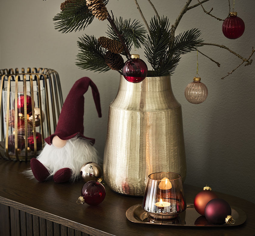 Goldener Kerzenständer, Weihnachtselfen und goldene Vase mit Fichtenzweigen und Weihnachtskugeln 