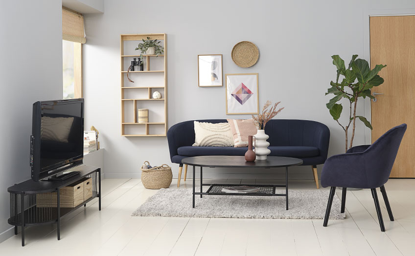 Wohnzimmer mit schwarzer TV-Bank, Sofa, Couchtisch und Sessel 
