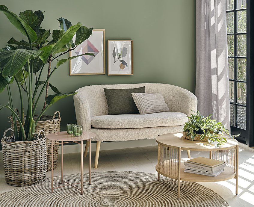 Wohnzimmer mit weißem Sofa, Couchtisch aus Eiche und Grünpflanzen 
