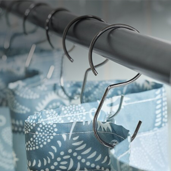 Shower rails Close-up of chrome shower curtain rings clipped to a rod, holding a blue floral-patterned fabric shower curtain liner.