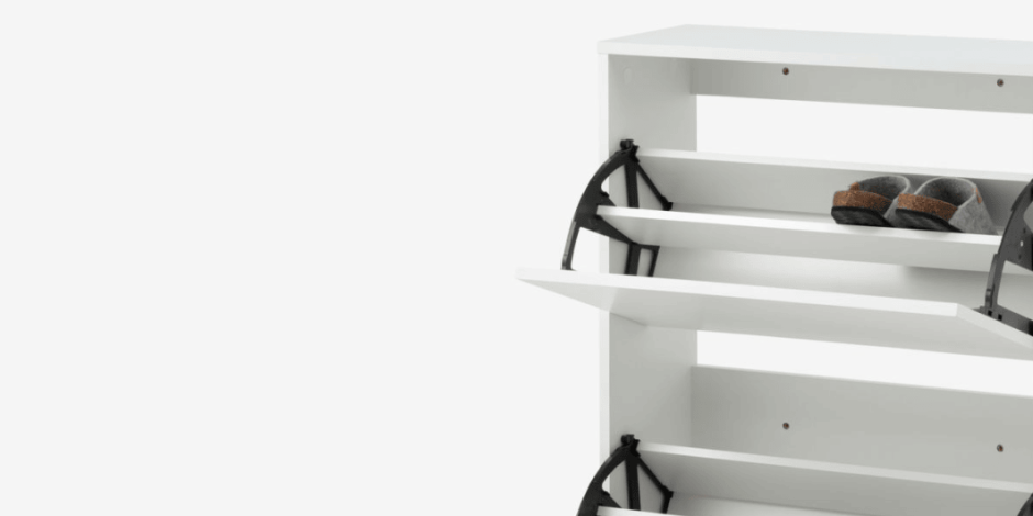 Shoe storage White shoe cabinet with tilting drawers holding slippers and shoes, shown against a plain white background.