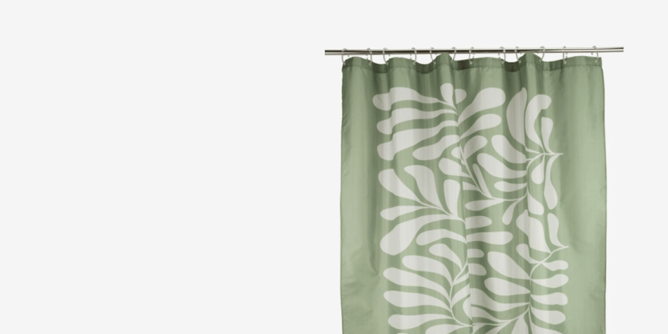 Shower curtains Sage green shower curtain with a white leaf pattern, hanging from a rod against a plain light background.