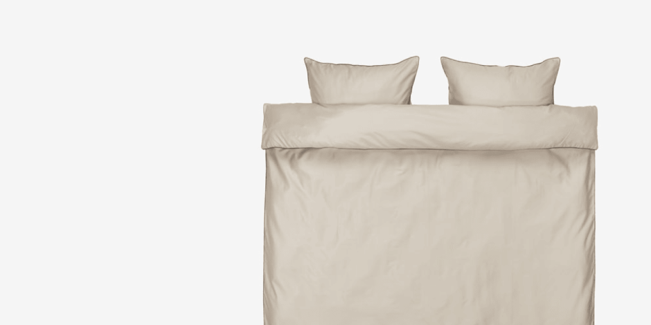 Beige duvet cover set with matching pillowcases, shown folded flat against a plain light grey background. Duvet cover set
