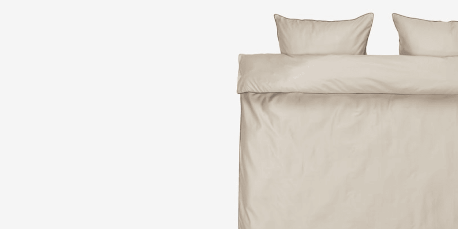 Duvet cover set Beige duvet cover set with matching pillowcases, shown folded flat against a plain light grey background.